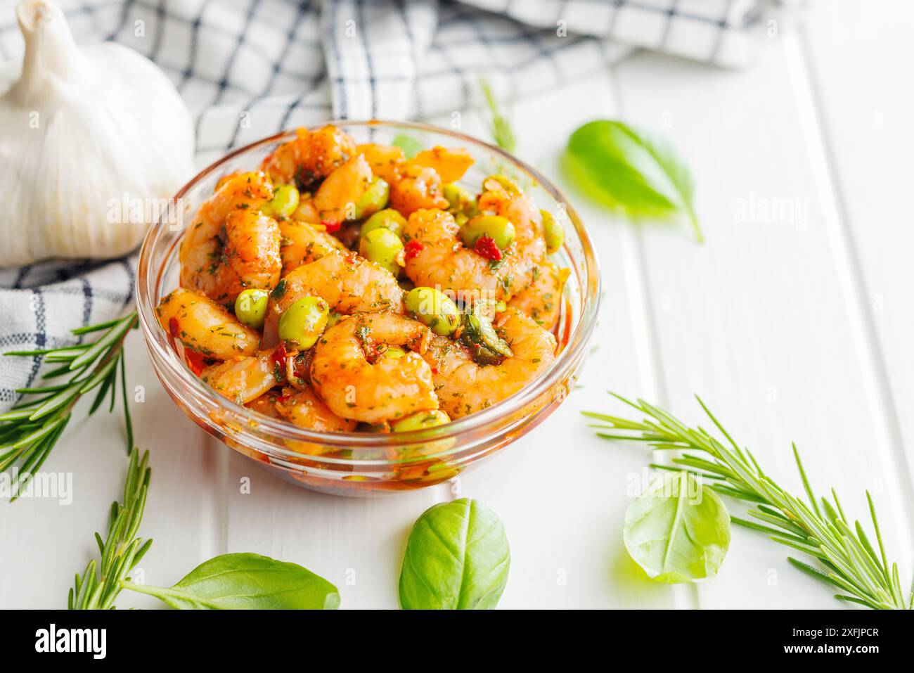 Salade fraîche avec crevettes et soja edamame dans un bol sur une table blanche. Banque D'Images