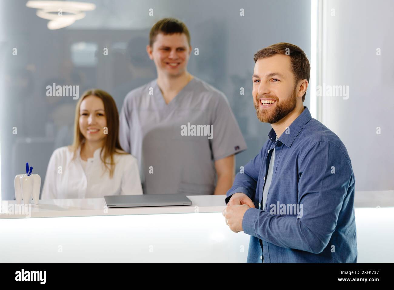 Patient reconnaissant. Homme debout à la réception de la clinique dentaire et très heureux pour le traitement Banque D'Images