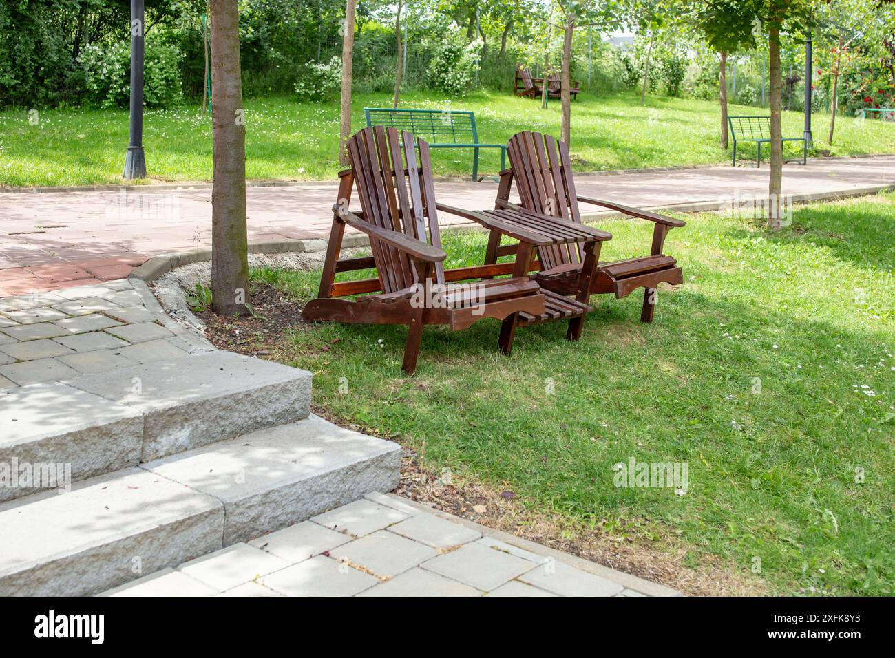 Chaises Adirondack avec une table dans un parc à côté d'une ruelle, Banque D'Images