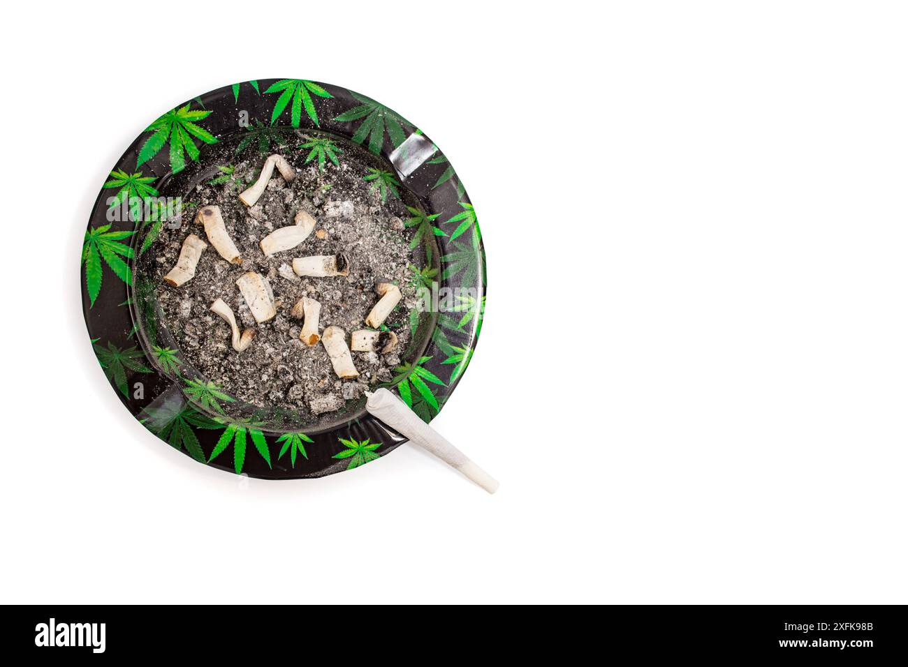 Cigarette commune de marijuana sur un cendrier sale avec motif de feuilles de cannabis, plat isolé Banque D'Images