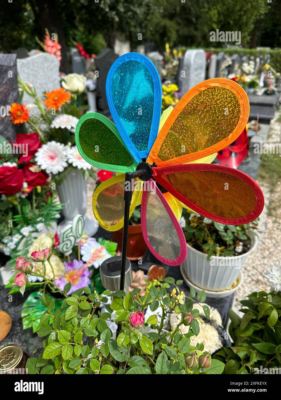 Roue à vent colorée sur la pierre tombale dans le cimetière public Banque D'Images