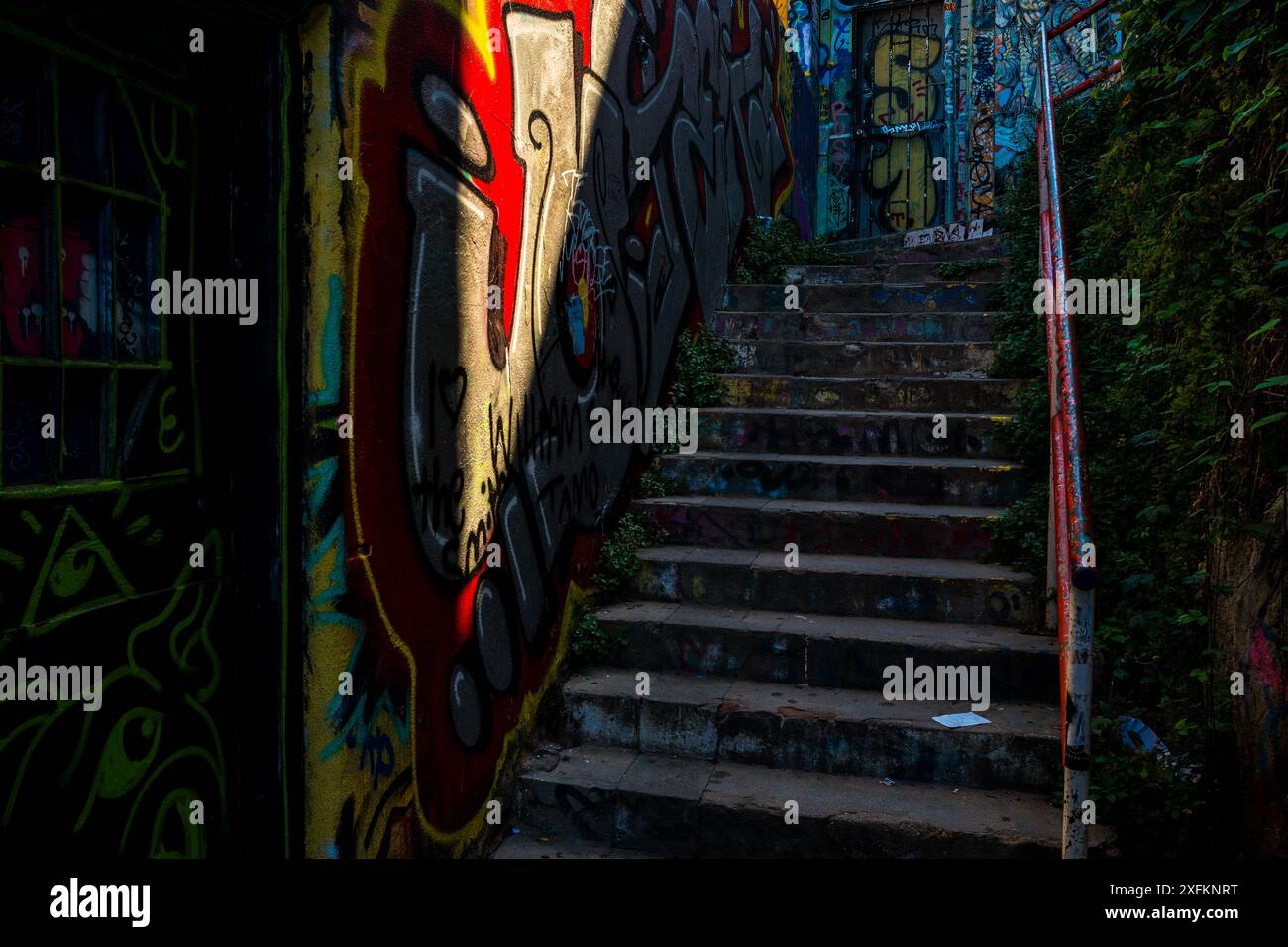 Un escalier sombre, entouré de graffitis, est vu sur la colline de Cerro Alegre à Valparaíso, Chili. Banque D'Images