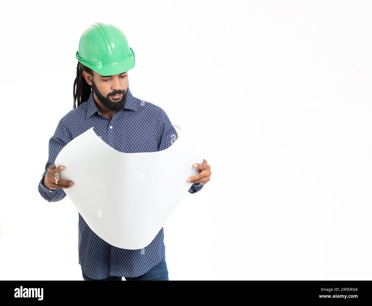 Architecte jeune adulte latin avec HardHat vert , dreadlocks chemise bleue et plans . caraïbes Banque D'Images