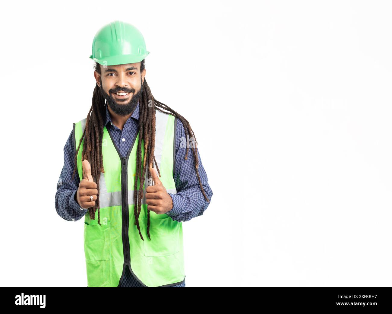 Architecte jeune adulte latin avec HardHat vert , dreadlocks chemise bleue et gilet de sécurité vert. caraïbes Banque D'Images