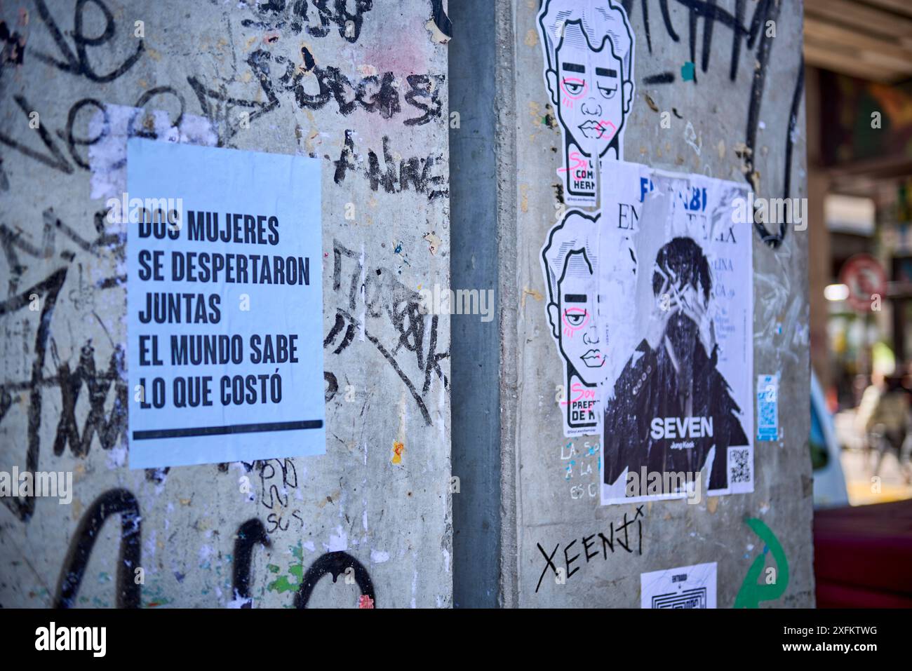 Site urbain. Colonnes avec griffonnages, griffonnages, affiches, peintures et écritures désordonnées. Un message sur les femmes ensemble peut être lu Banque D'Images