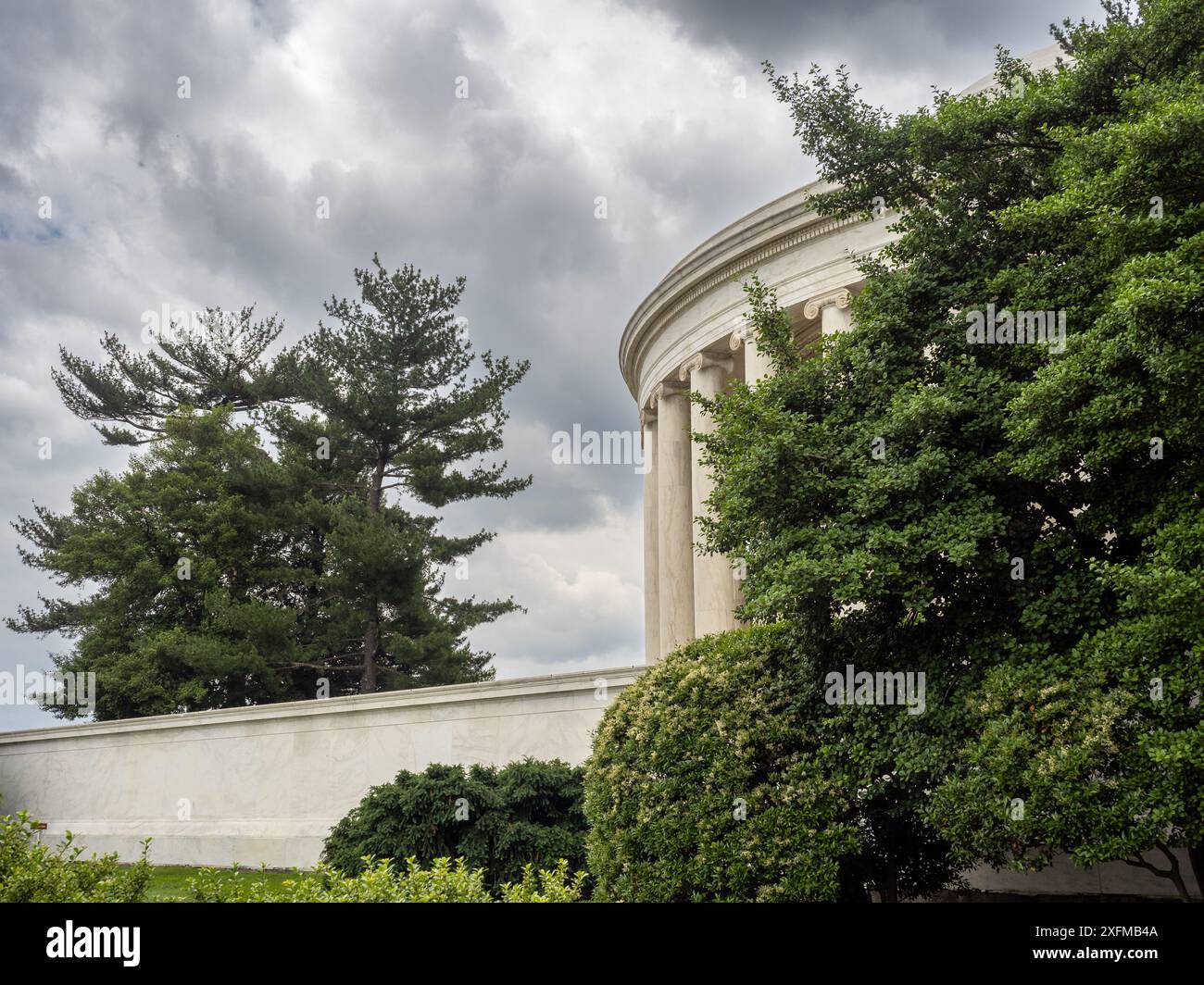 Le Lincoln Monument à Washington D.C. capturé par derrière, encadré par une canopée d'arbres vibrants et luxuriants, créant une scène dynamique et captivante. Banque D'Images