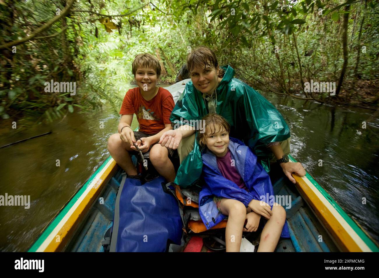 Cheryl Knott, chercheuse d'orangs-outans, et des enfants descendent la rivière en bateau depuis la station de recherche de Cabang Panti, dans le parc national de Gunung Palung, à Bornéo. Sortie du modèle en août 2010. Banque D'Images