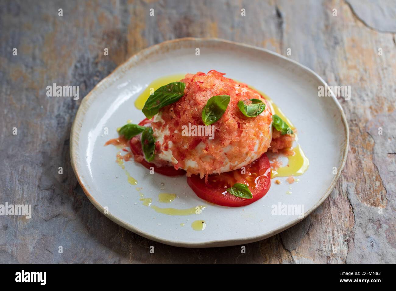 Burrata avec tomates congelées, basilic et huile d'olive Banque D'Images