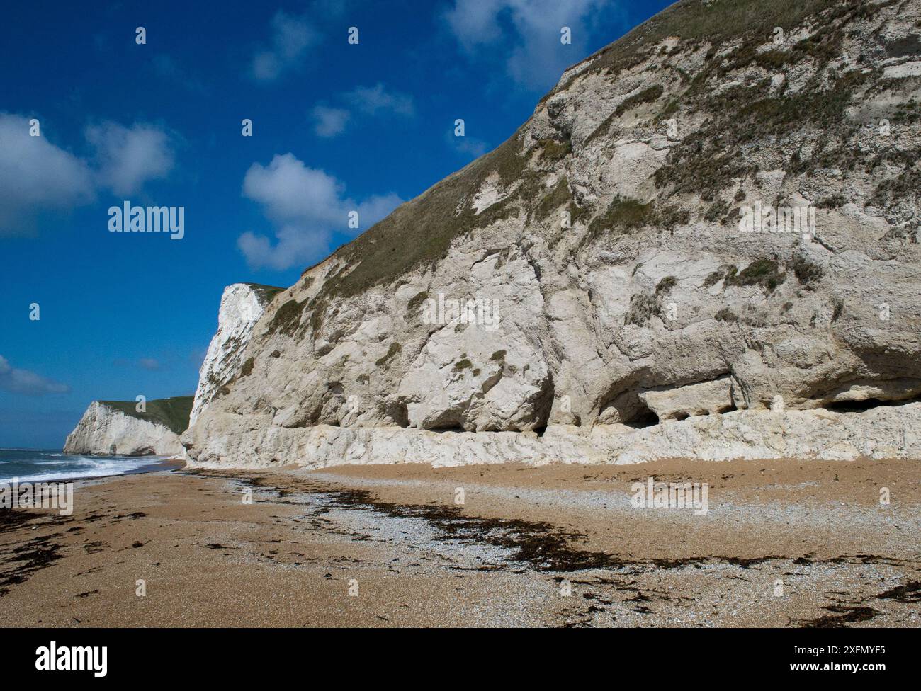 Faille normale tournée dans la craie du Crétacé avec érosion, petites grottes à la base. Lits de craie verticaux et parallèles à la falaise, Durdle Door, Jurassic Coast, Dorset, Angleterre, avril 2012. Banque D'Images Faille normale tournée dans la craie du Crétacé avec érosion, petites grottes à la base. Lits de craie verticaux et parallèles à la falaise, Durdle Door, Jurassic Coast, Dorset, Angleterre, avril 2012. Banque D'Images