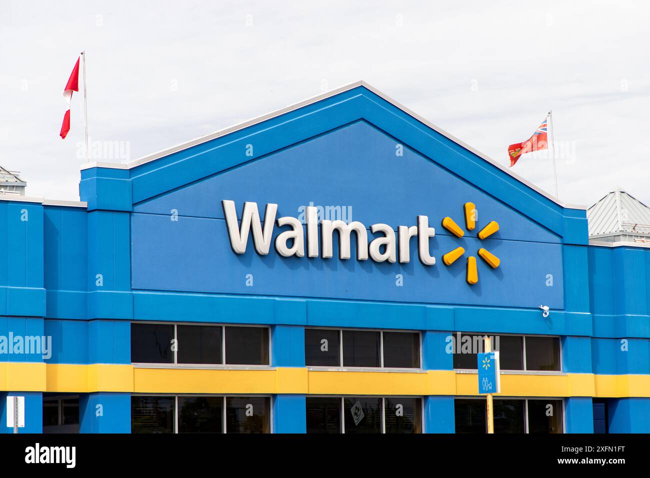 Kanata, Canada - 2 juin 2024 : immeuble de magasins de détail Walmart avec drapeaux canadiens et ontariens Banque D'Images