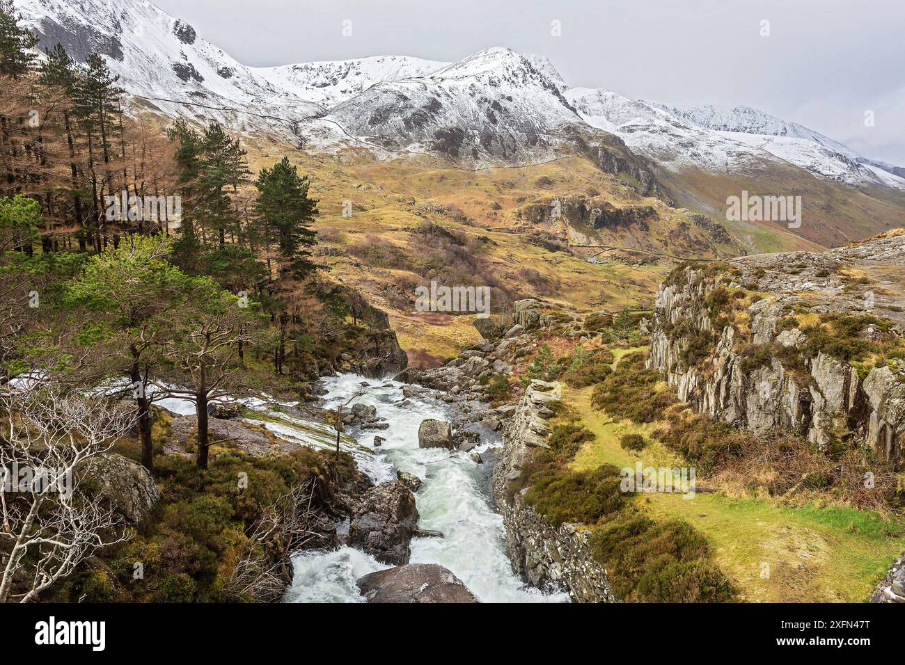 Vue sur les chutes d'Ogwen depuis le pont sur la route A5 avec la vallée de Nant Francon et la montagne Foel Goch en arrière-plan Snowdonia, pays de Galles du Nord, Royaume-Uni, mars. Banque D'Images