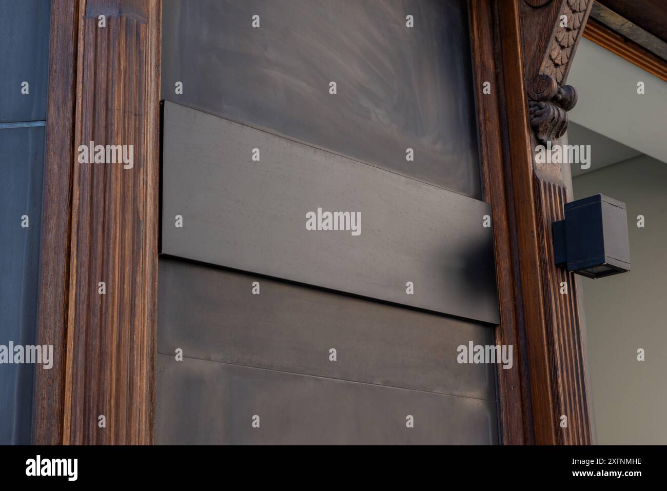 Tableau noir sur surface en bois à l'entrée de la boutique ou du restaurant pour la promotion du logo. Parfait pour mettre en valeur l'identité de la marque et la publicité opportune Banque D'Images