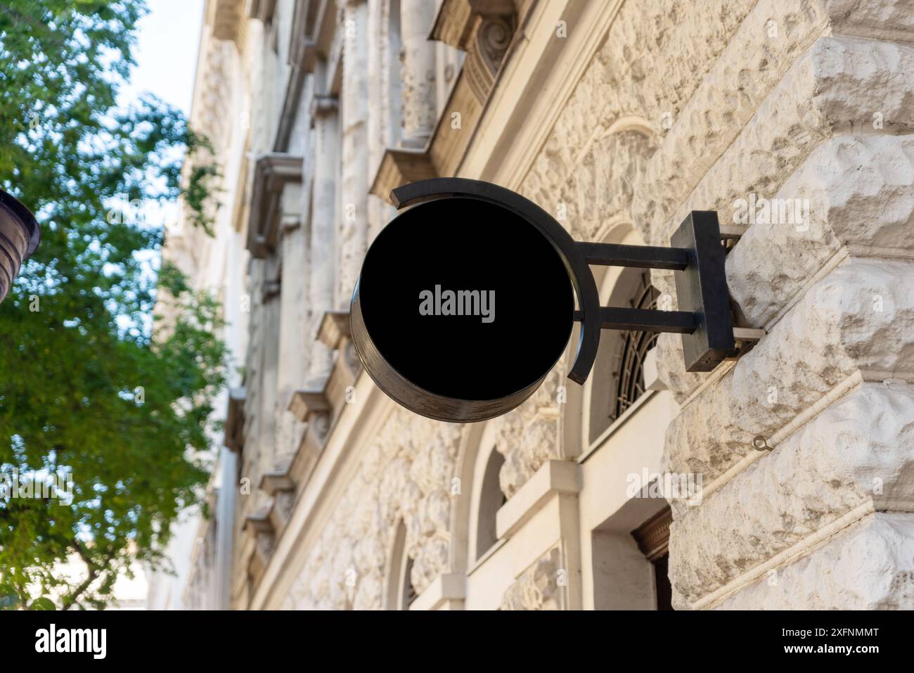 Signe rond moderne d'entreprise sur une façade de ville en noir. Combine un design contemporain avec le charme de la ville pour une image de marque efficace Banque D'Images