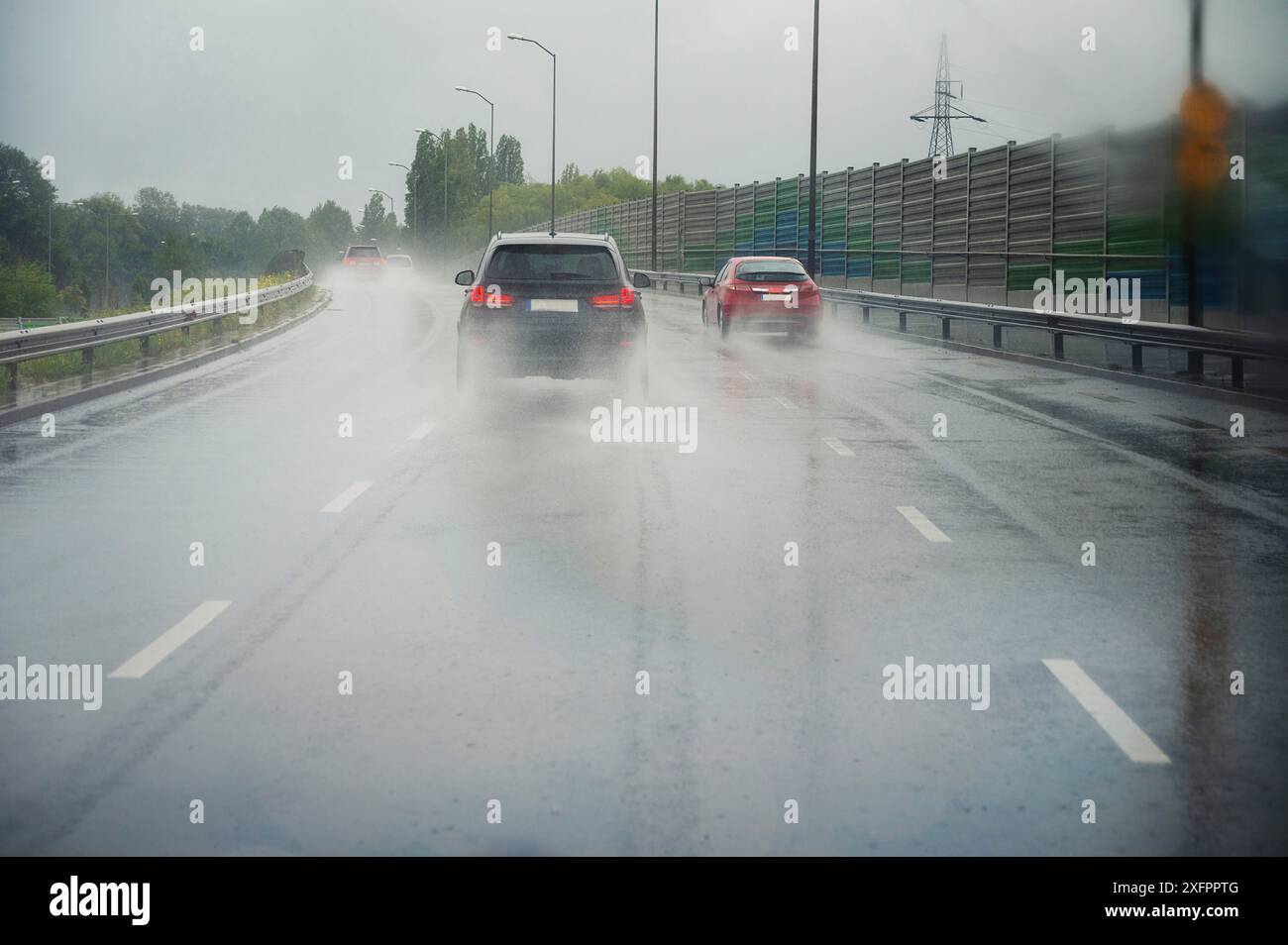 Voitures conduisant sur la route, forte pluie, faible visibilité, rue glissante, tempête dangereuse, temps couvert Banque D'Images