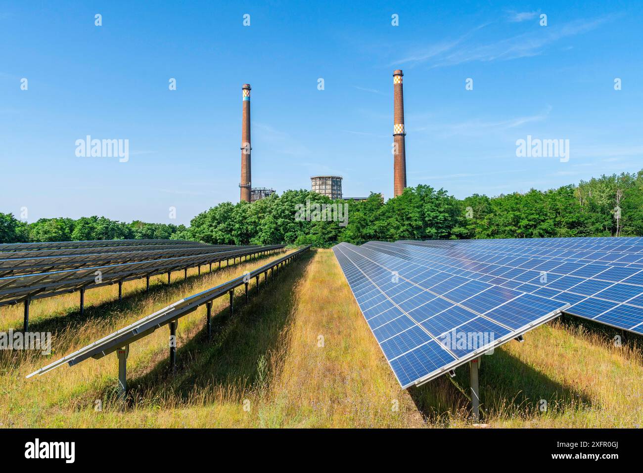 Modules solaires d’un parc solaire devant la centrale thermique au lignite de Plessa déclassée avec deux cheminées et des tours de refroidissement, Plessa, Lusatia Banque D'Images