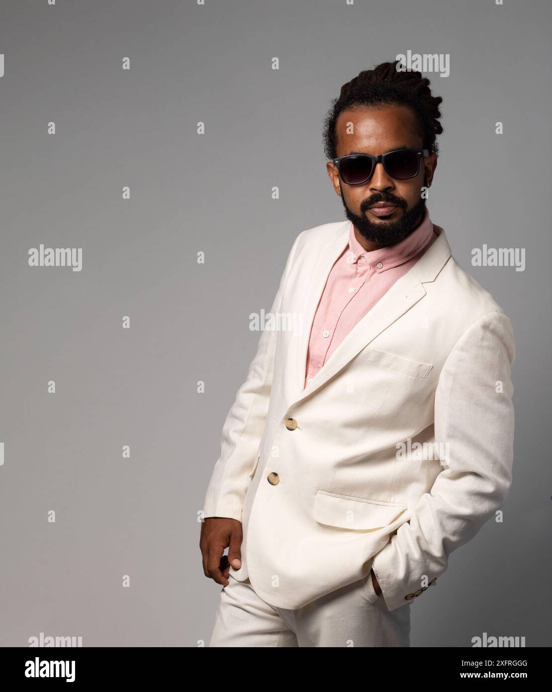 afro cubain avec des dreadlocks en costume avec des lunettes de soleil regardant l'appareil photo isolé Banque D'Images