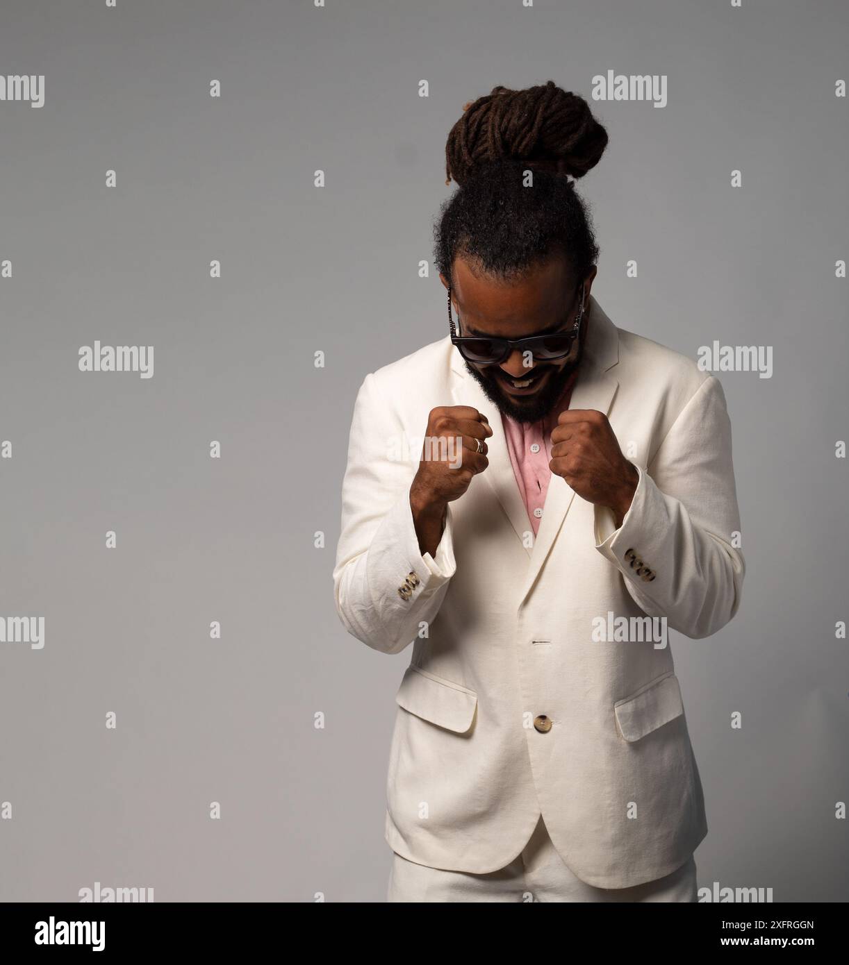 afro cubain avec des dreadlocks en costume célébrant des lunettes de soleil wearin isolé Banque D'Images