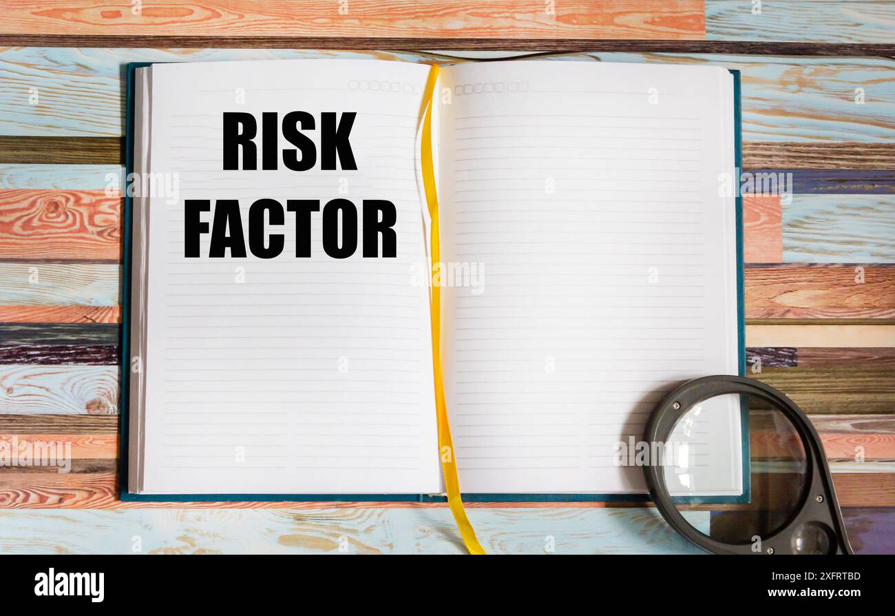 Bloc-notes avec facteur de risque de texte sur fond vintage avec loupe Banque D'Images