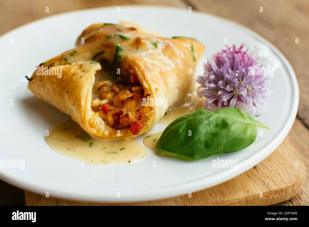 Wellington végétal avec une garniture de riz et légumes mélangés, et une sauce au vin végétalien. Banque D'Images