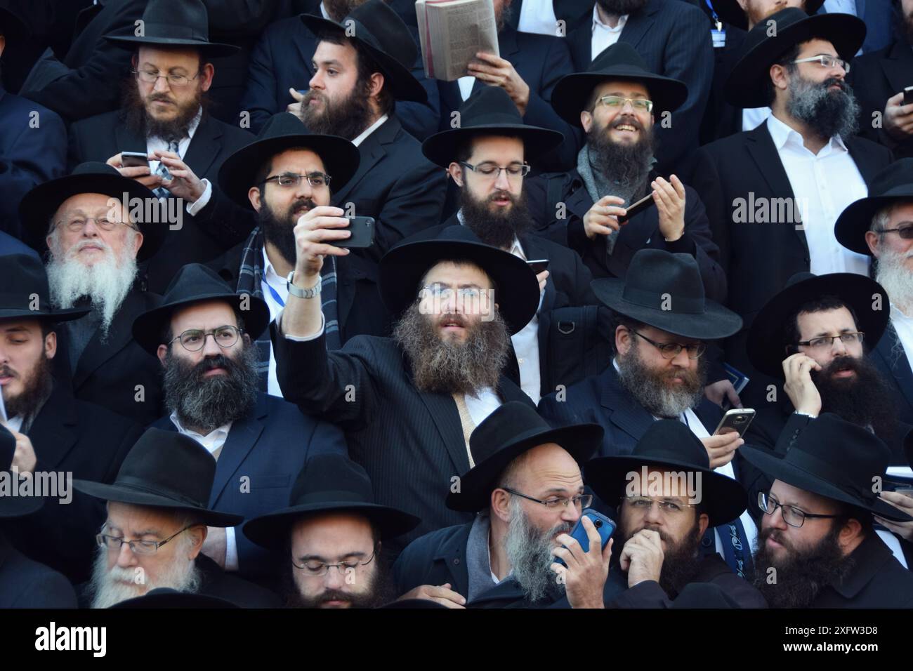 Lors de la convention annuelle Chabad des émissaires, un rabbin hassidique prend un selfie d'autres rabbins sur la photo de groupe. À Crown Heights, Brooklyn, NYC. Banque D'Images
