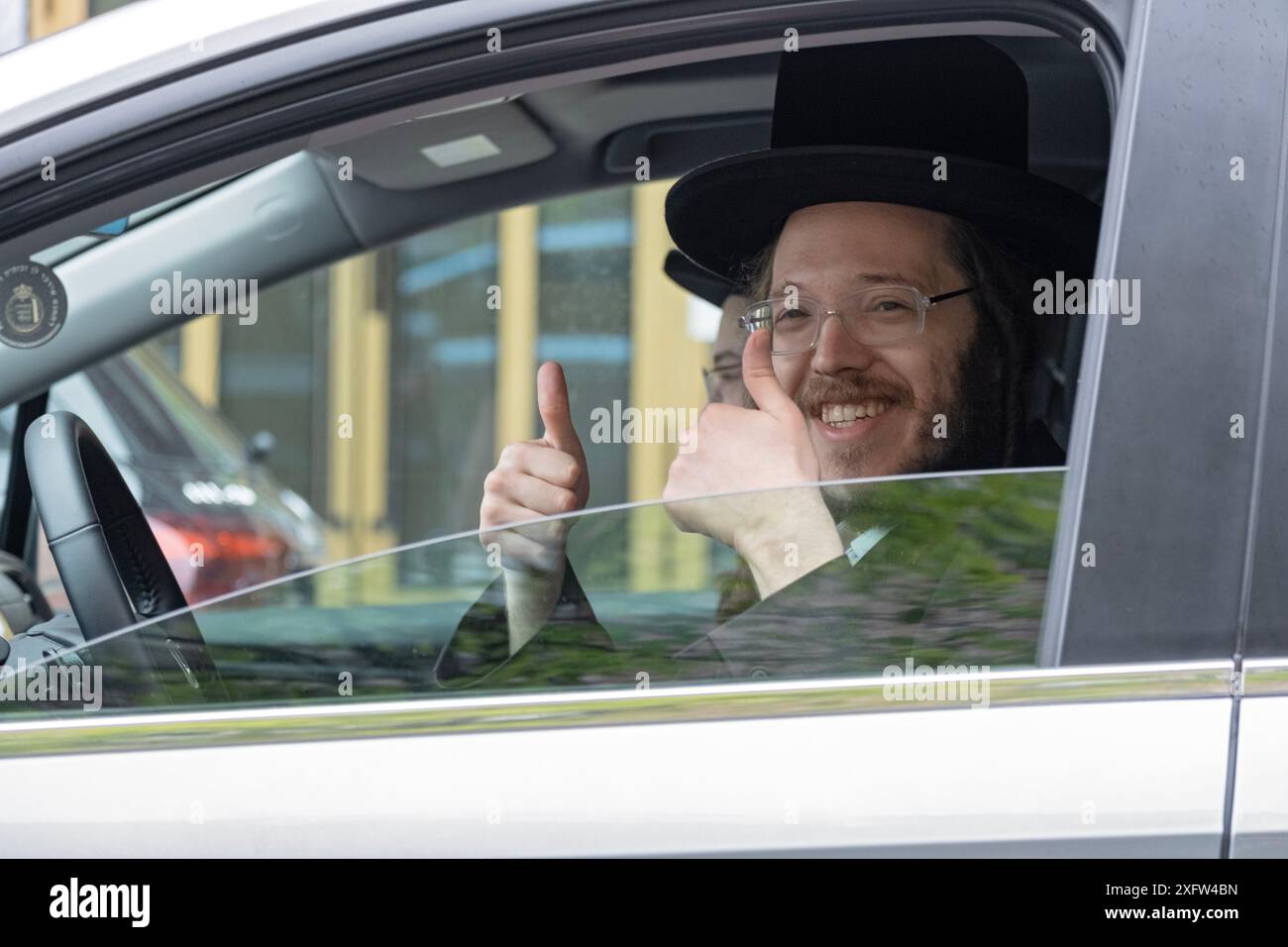 Un homme juif hassidique souriant donne à cette photo un pouce levé et un grand sourire. À Williamsburg, Brooklyn, New York. Banque D'Images