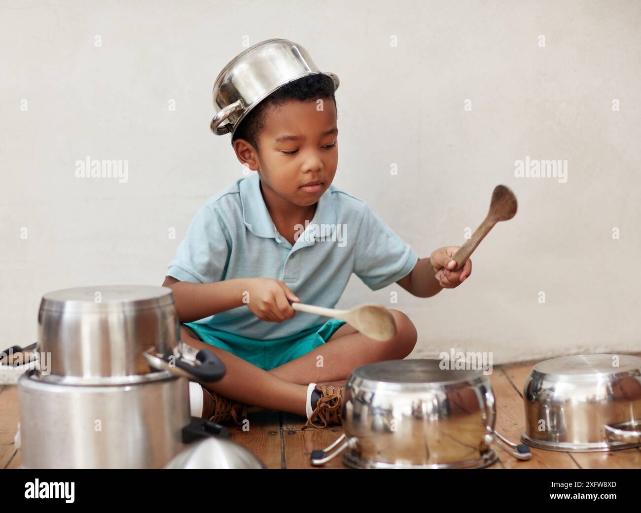 Maison, enfant et bruit de pots pour tambour, rythme et coordination pour la motricité avec rythme métal. Créativité, garçon musicien et talent avec le son Banque D'Images