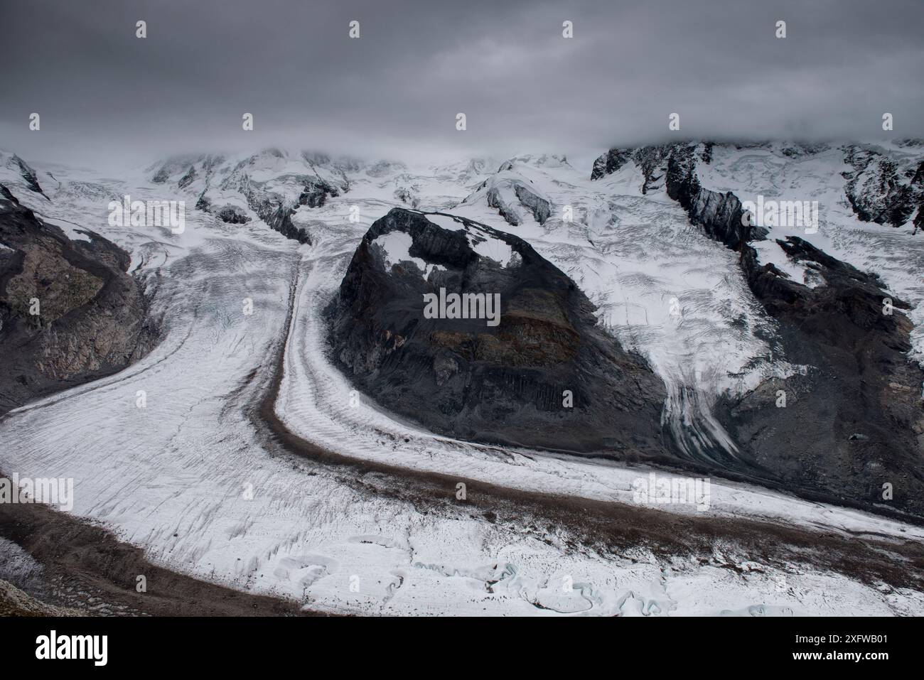 Le glacier du Gorner avec le Briethorn dans les nuages, Valais, Suisse. Septembre 2017. Le glacier a une moraine médiale qui longe son centre, formée lorsque deux glaciers avec des moraines latérales fusionnent. Banque D'Images