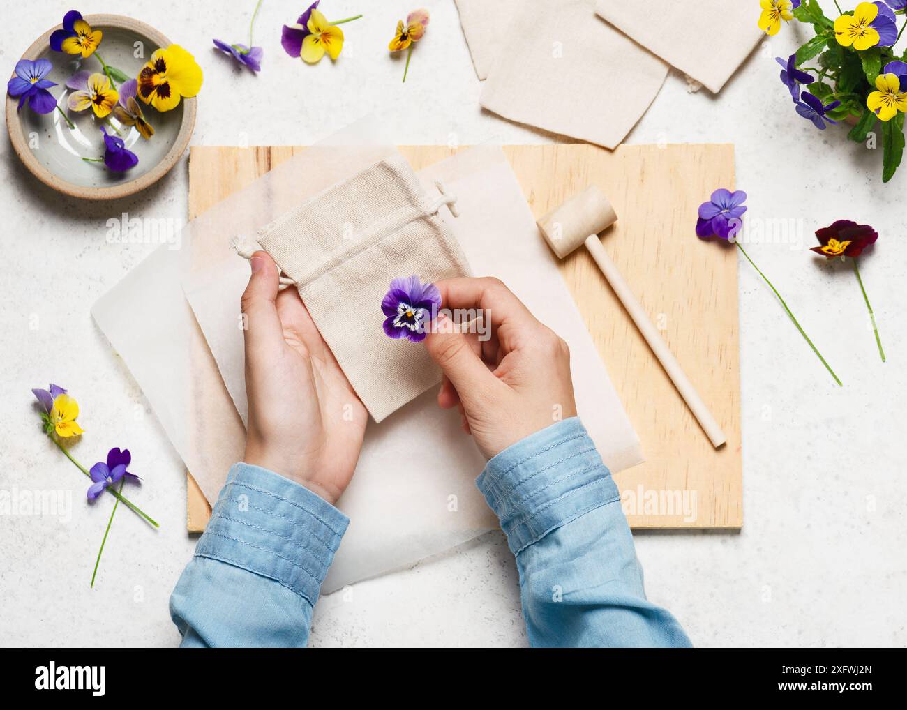 Étape 1. Disposez un sac en tissu sur une surface dure et placez les fleurs dessus. Imprimés fleurs martelées sur tissu. Artisanat naturel facile Banque D'Images