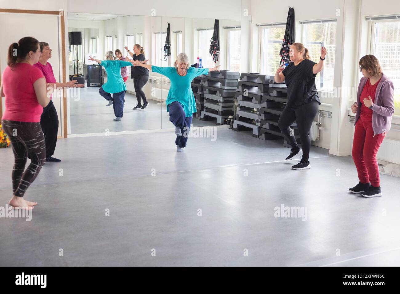 Instructeur féminin dansant avec des étudiants au studio de danse Banque D'Images