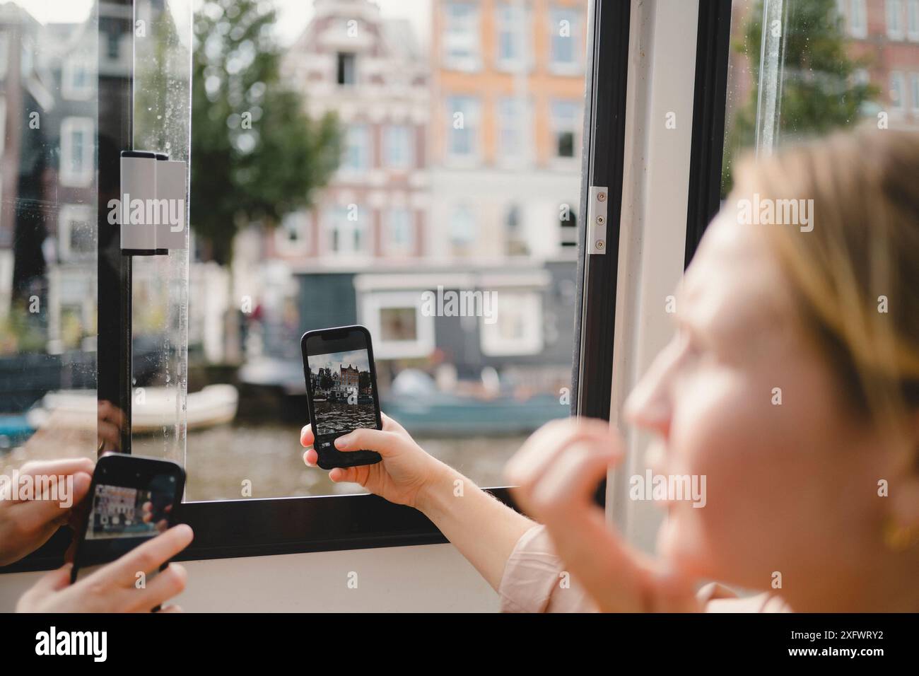 Femme photographiant un canal à Amsterdam Banque D'Images