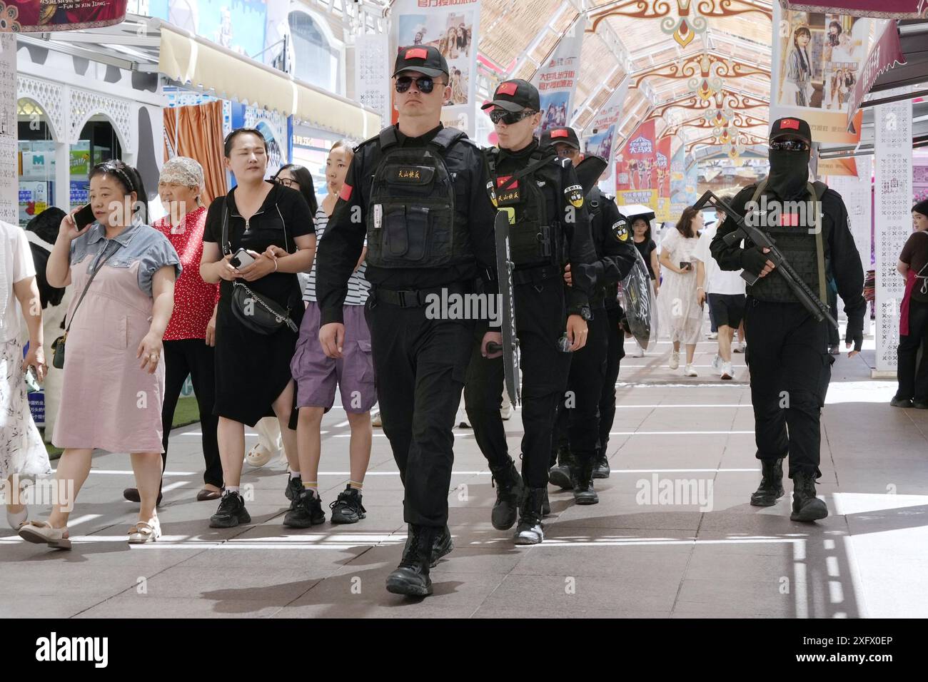 Des policiers armés patrouillent au Grand Bazar à Urumqi, dans la région autonome ouïghoure du Xinjiang, le 5 juillet 2024, à l'occasion du 15e anniversaire de l'émeute d'Urumqi qui a fait environ 200 morts. (Kyodo)==photo Kyodo via Credit : Newscom/Alamy Live News Banque D'Images