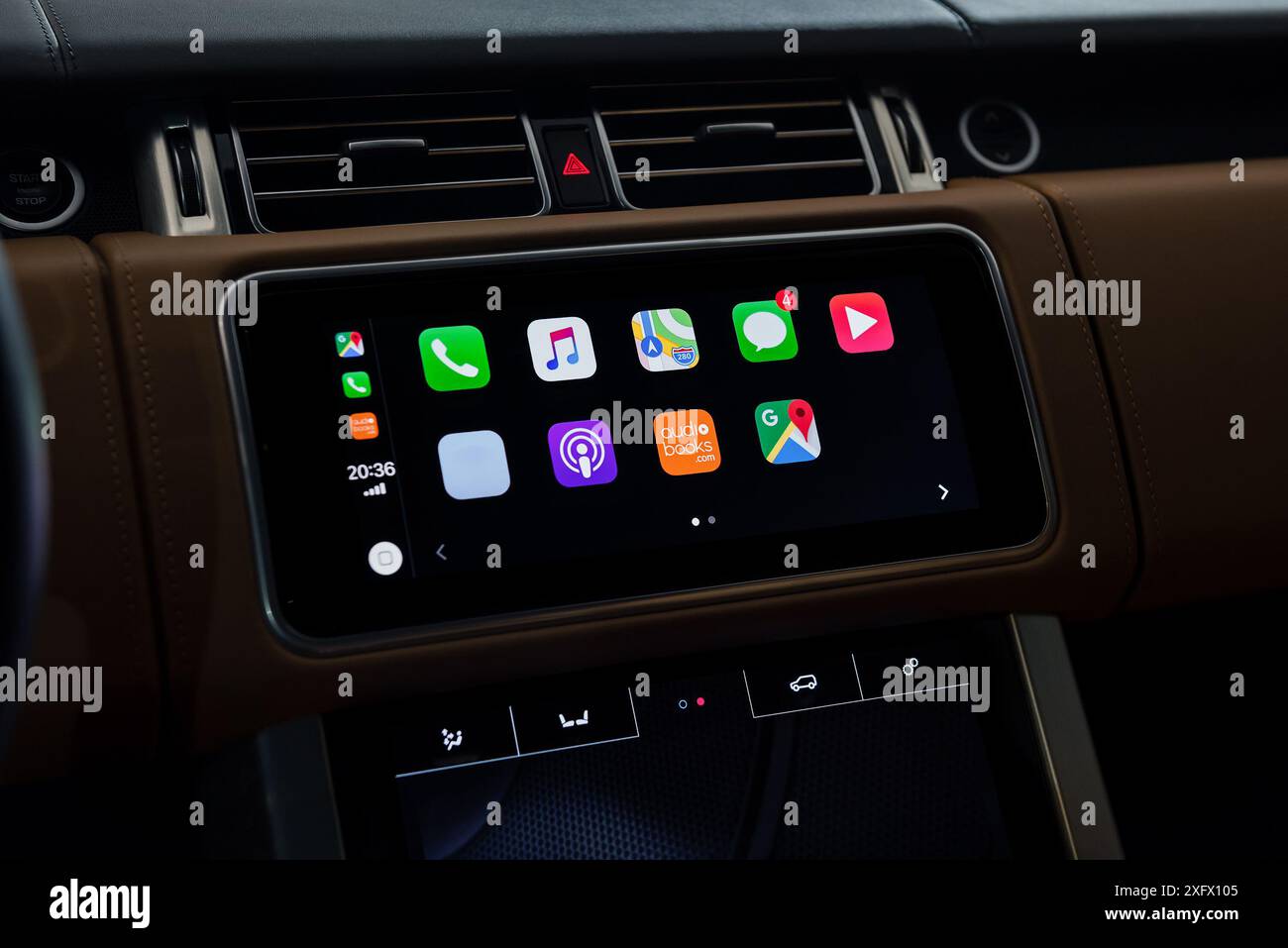 Menu de l'écran principal Apple CarPlay dans la voiture exécutive. Intérieur de la voiture garni de cuir la nuit, gros plan du système d'infodivertissement. Banque D'Images