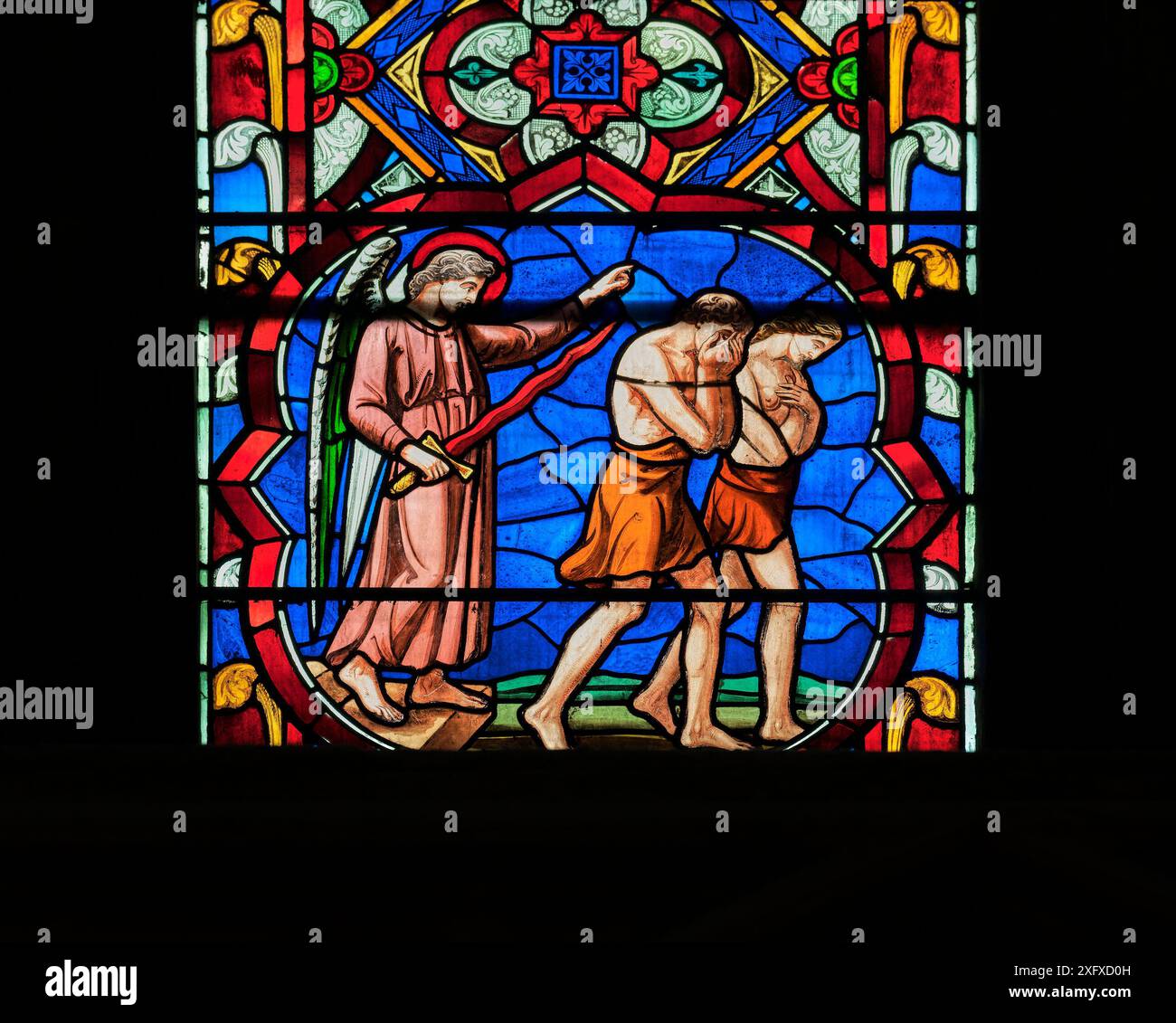 Un ange avec une épée flamboyante bannit Adam et Ève du jardin d'Eden ; fenêtre dans la cathédrale gothique médiévale chrétienne à Lincoln, en Angleterre. Banque D'Images