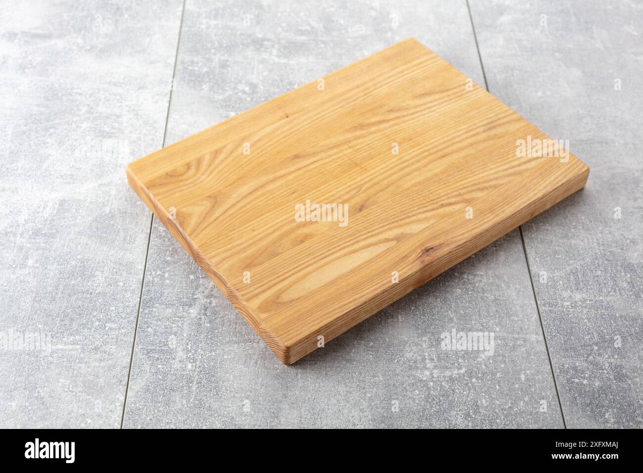 Planche à découper sur une table de cuisine. Fond culinaire. Planche à découper en bois vide, espace d'affichage du produit. Banque D'Images