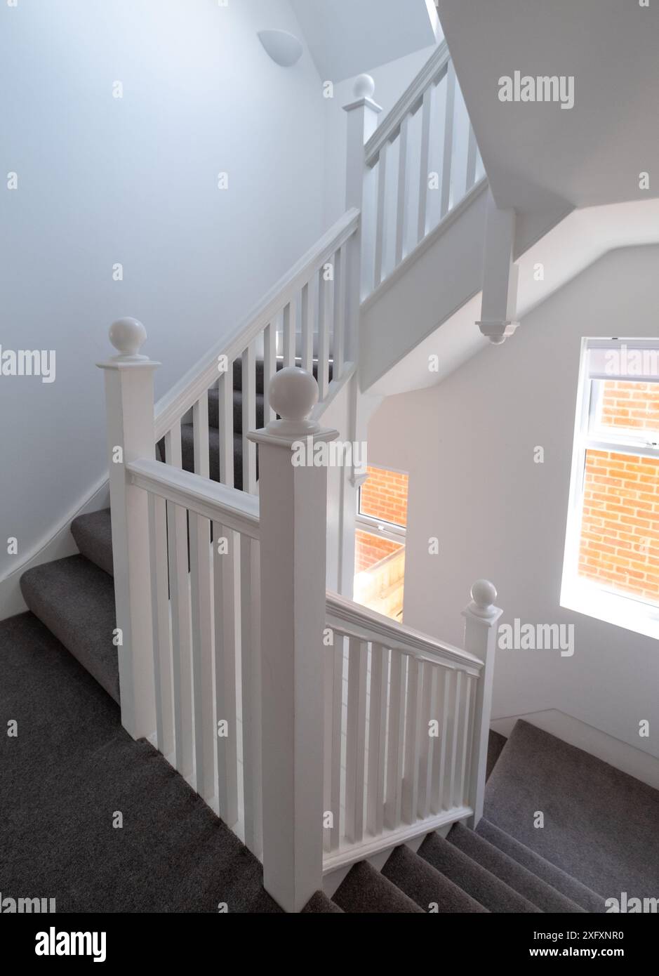 Rénové, peint en blanc, escalier en bois avec de simples lattes verticales, dans une maison édouardienne, au nord-ouest de Londres Royaume-Uni. Banque D'Images