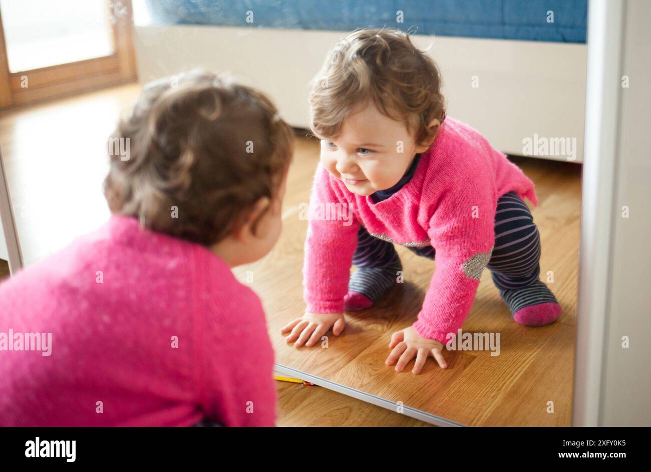 Bébé Enfant fille jouant avec miroir dans la chambre à coucher. Banque D'Images