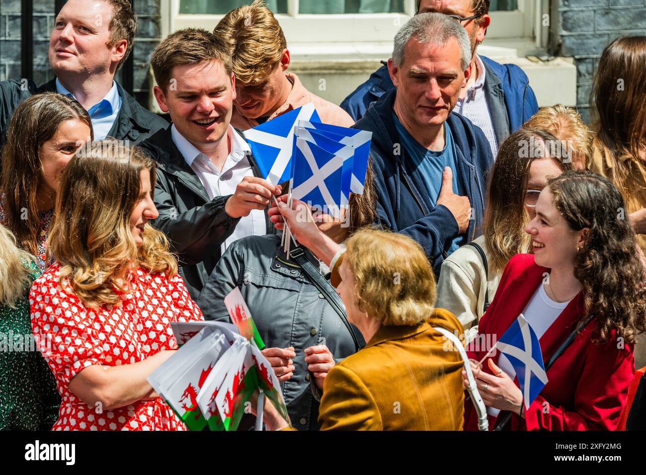 Londres, Royaume-Uni. 5 juillet 2024. Les officiels du parti émettent des syndicalistes Jacks, Saltires et le drapeau gallois (mais pas de croix de St George) aux partisans et aux travailleurs du parti alors qu'ils attendent le nouveau premier ministre, Sir Keir Starmer à Downing Street après la grande victoire électorale du parti travailliste. Crédit : Guy Bell/Alamy Live News Banque D'Images