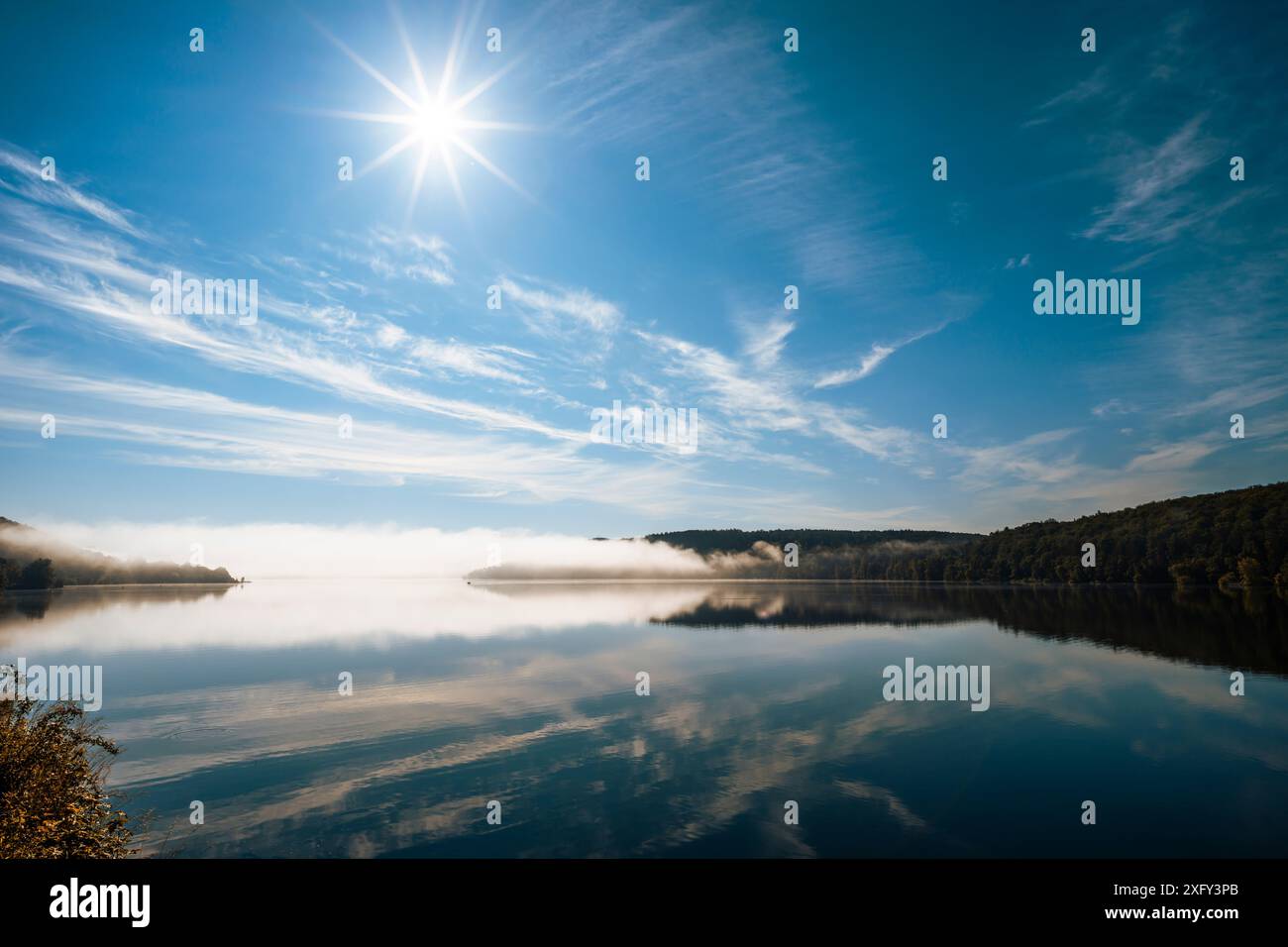 Réservoir du lac Edersee par un matin ensoleillé, léger brouillard au loin, réflexion sur l'eau calme. District de Waldeck-Frankenberg, Hesse, Allemagne. Banque D'Images