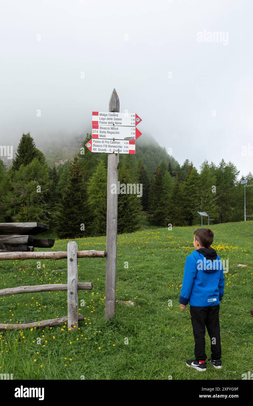 Apprendre à lire les panneaux de montagne avec des indications de lieu, d'itinéraire et de timing, c'est agréable de pouvoir enseigner tout cela aux plus petits. Europe, Italie, Trentino Tyrol du Sud, non vallée, Trento province, CLES Banque D'Images