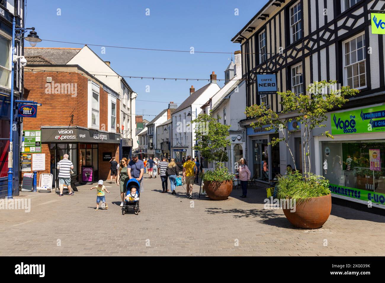 Rue commerçante avec jardinières en métal rouge, Abergavenny, pays de Galles, Royaume-Uni Banque D'Images