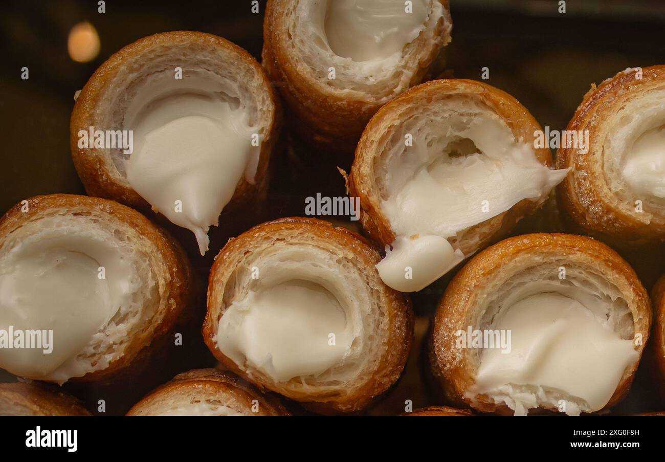 Petits pains sucrés italiens à la crème au chocolat blanc à Milan. Rouleaux de canolli sicilien, сuisine en Italie. Café et bonbons Banque D'Images