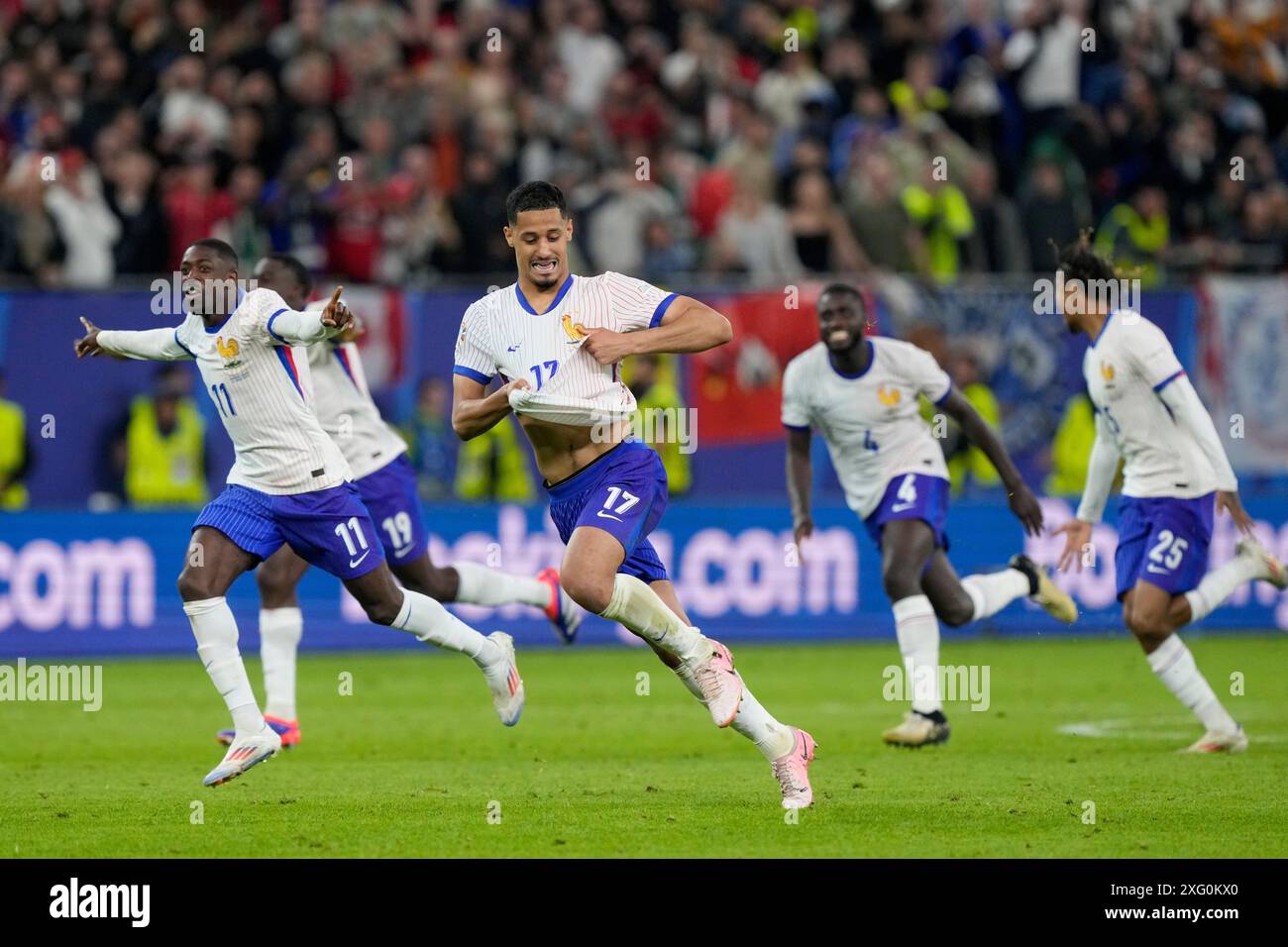 William Saliba of France, center, runs celebrating after Theo Hernandez of France scored the winning igoaln a penalty shootout after the match end goalless during a quarter final match between Portugal and France at the Euro 2024 soccer tournament in Hamburg, Germany, Friday, July 5, 2024. (AP Photo/Martin Meissner) Banque D'Images