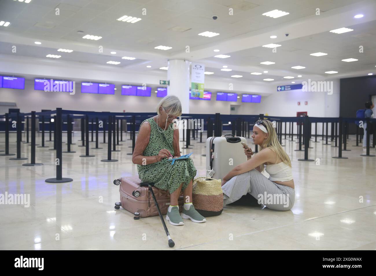 Cancun, Mexique. 5 juillet 2024. Les voyageurs attendent à l'intérieur de l'aéroport international de Cancun après l'arrivée de l'ouragan Beryl, à Cancun, dans l'état de Quintana Roo, au Mexique, le 5 juillet, 2024. dans les Caraïbes, plus d'un million de personnes ont été touchées par l'ouragan Beryl, ont déclaré vendredi les humanitaires des Nations Unies. Ouragan de catégorie 4 qui a fait au moins 11 morts à ce jour, Beryl a laissé lundi une traînée de destruction à Grenade et Saint-Vincent-et-les Grenadines, puis a touché la Jamaïque mercredi. L'ouragan affecte actuellement le Belize et le Mexique. Crédit : Alberto Valdez/Xinhua/Alamy Live News Banque D'Images
