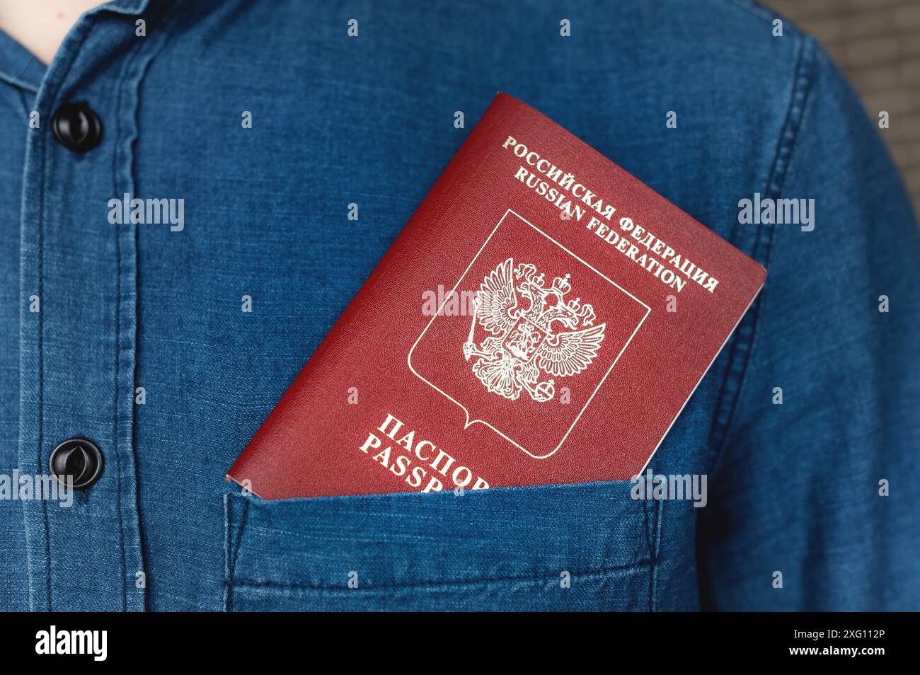 Passeport dans la poche d'une chemise en denim, gros plan. Concept voyage à l'étranger Banque D'Images