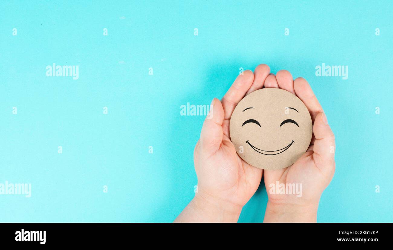 Tenir un visage joyeux souriant dans les mains, émotions positives, bons commentaires des clients Banque D'Images