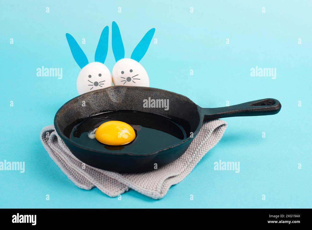 Deux drôles de pâques qui regardent dans une casserole avec un oeuf, carte de vœux des fêtes, saison de printemps Banque D'Images