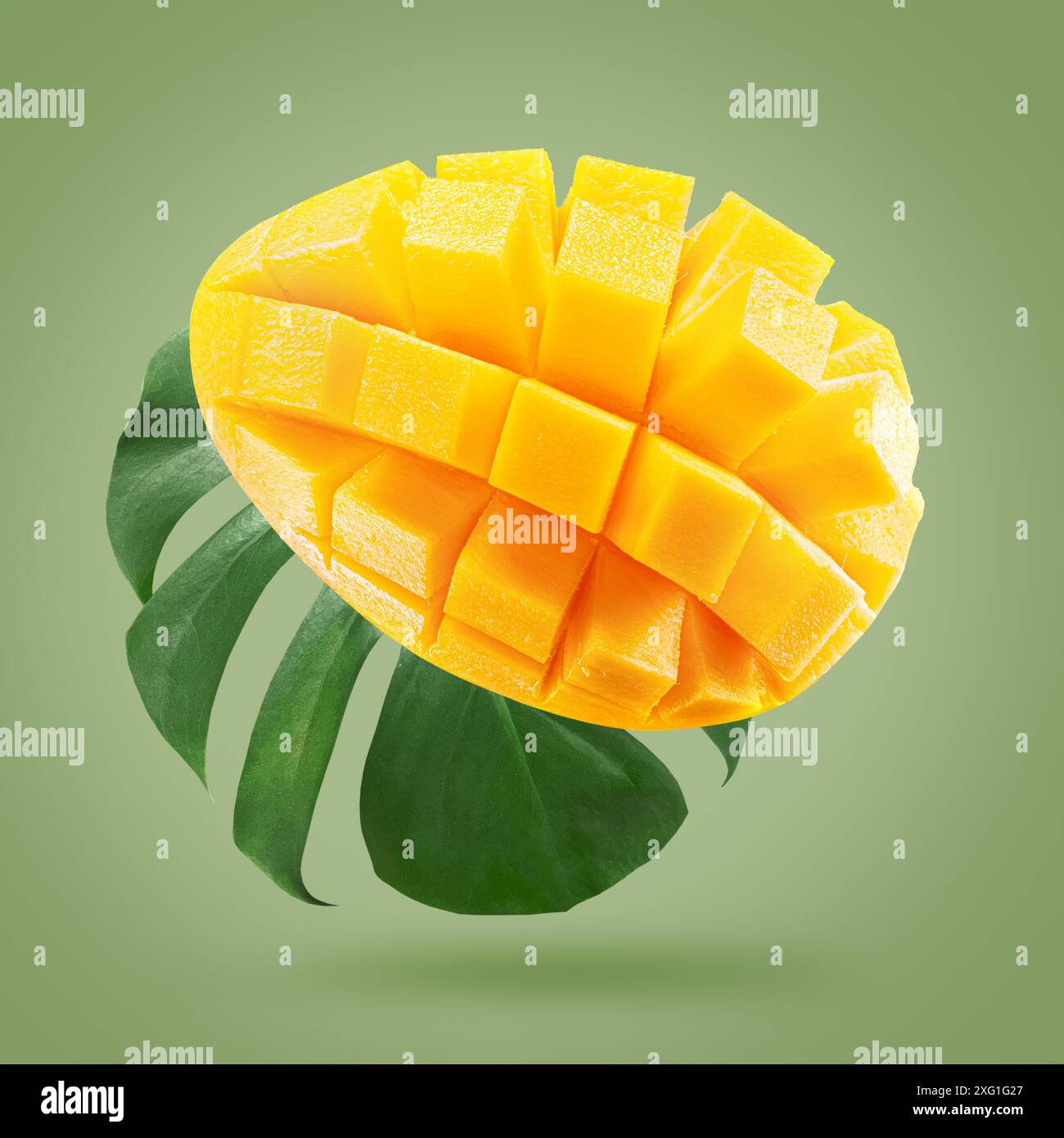 fruit de mangue avec feuille sur un fond vert clair.. Banque D'Images