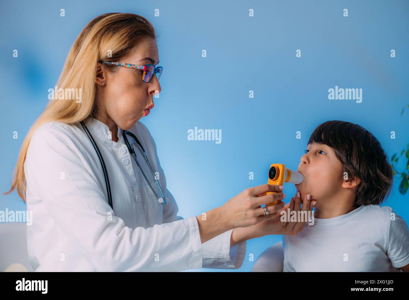 Pneumologue pédiatrique mesurant la capacité pulmonaire et le volume expiratoire-force d'un garçon. Banque D'Images