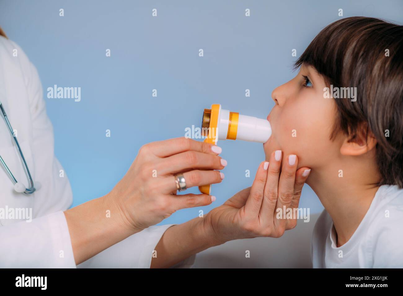 Pneumologue pédiatrique mesurant la capacité pulmonaire et le volume expiratoire-force d'un garçon. Banque D'Images