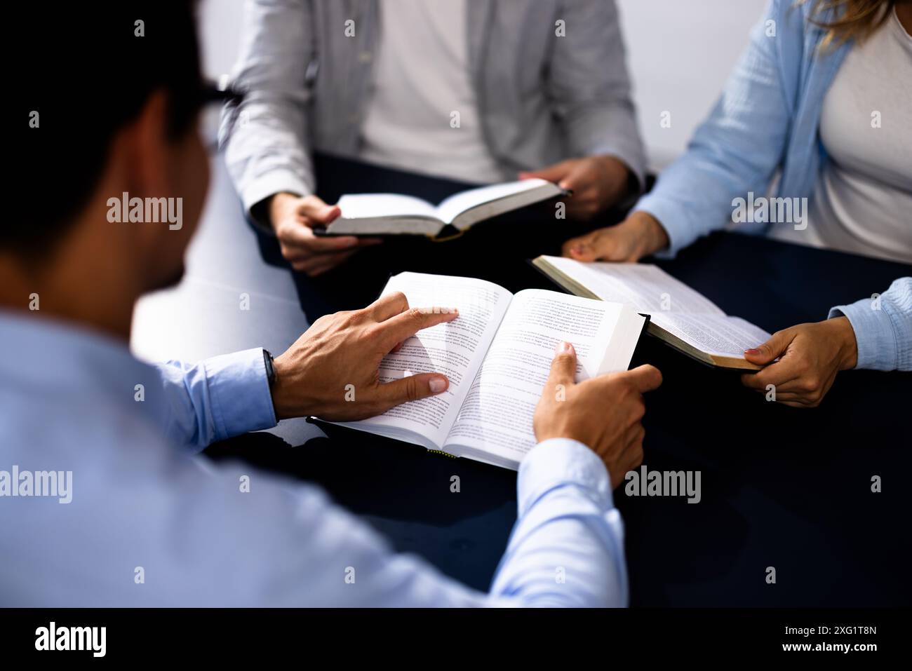 Prédicateur chrétien lisant la Sainte Bible avec des amis dans les cercles d'étude, hommes hispaniques et caucasiens priant pour la paix et la guidance Banque D'Images